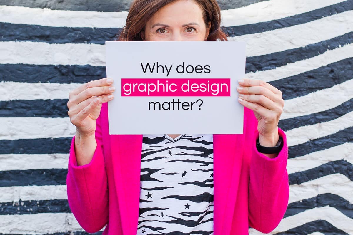 A woman holding a sign asking why graphic design matters